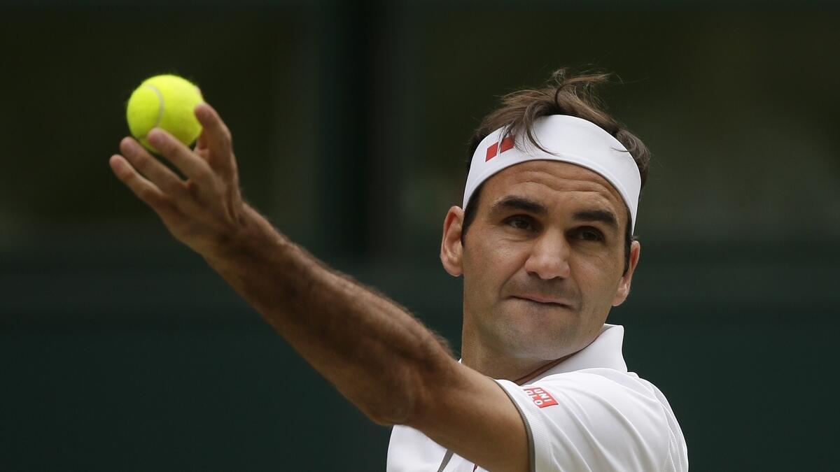 Roger Federer serves to Novak Djokovic during the men's singles final match of the Wimbledon Tennis Championships in London. AP