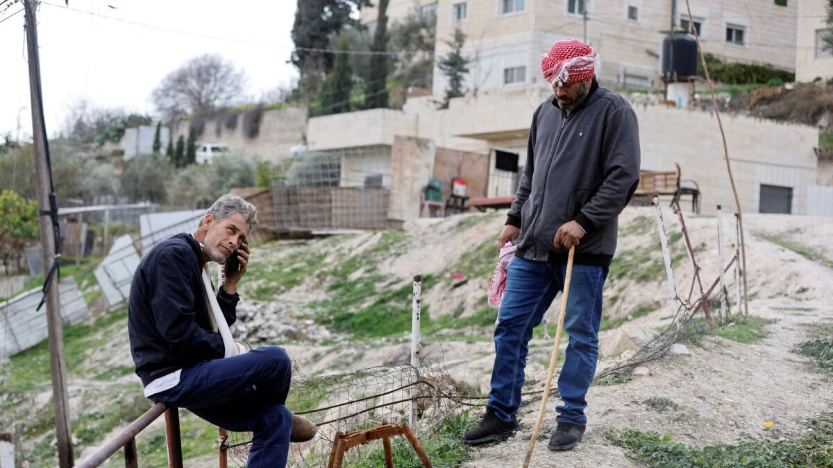 Moussa, the father of Palestinian gunman Khaire Alkam, and another family member gather outside the family home as it is sealed off, after Alkam killed people in a synagogue attack on the outskirts of Jerusalem, on Sunday. — Reuters