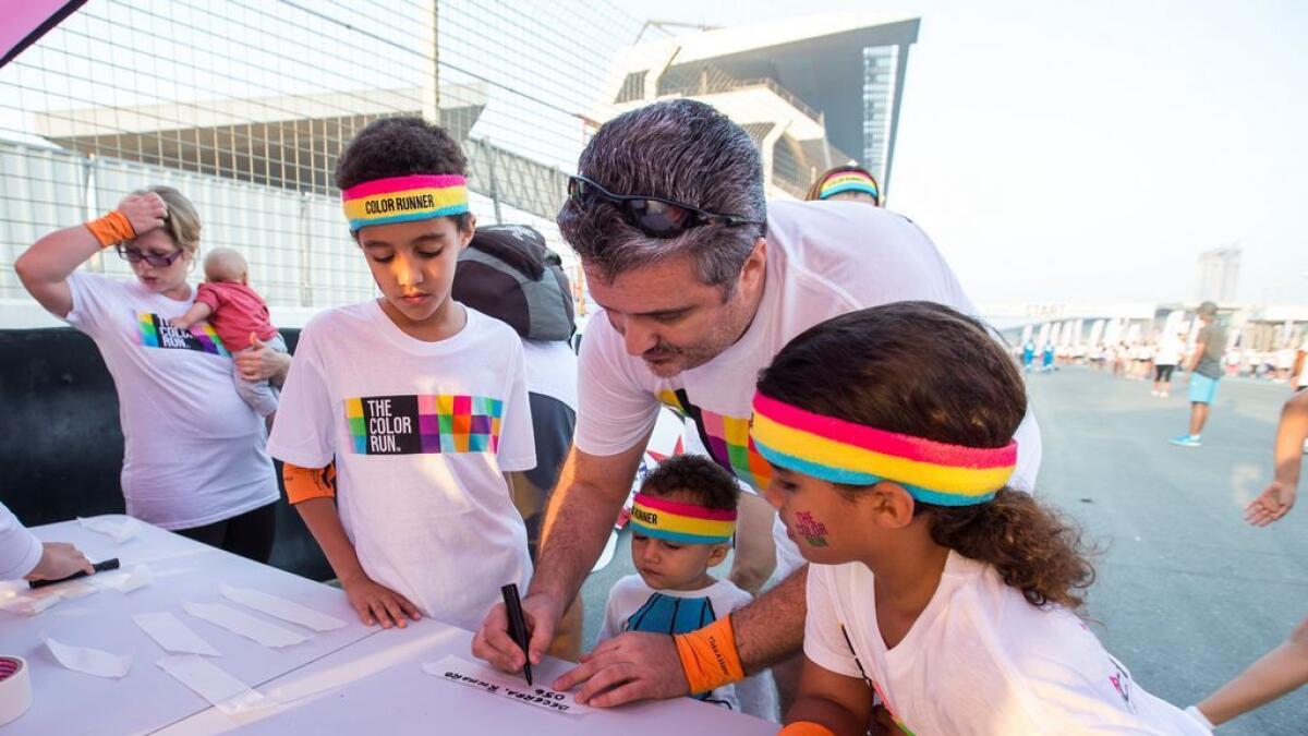 Adults and kids register for the Color Run at the Dubai Autodrome. -Photo by Leslie Pableo/ Khaleej Times