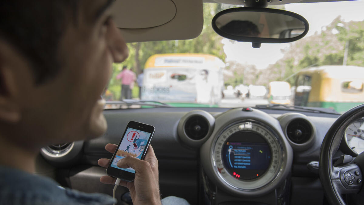 In this Friday, July 22, 2016 photo, Shivanu Mandal plays Pokemon inside a car in New Delhi, India. 'Pokemon Go,' the highly addictive online game, has landed in India and thousands are out searching for pokemon characters as the mania spreads. Although it has not been launched officially in India, the augmented-reality-based game has caught on, with fans also using virtual private networks (VPNs) to change their locations and catch pokemons in New York and London while sitting in their Indian homes. (AP Photo/Thomas Cytrynowicz)
