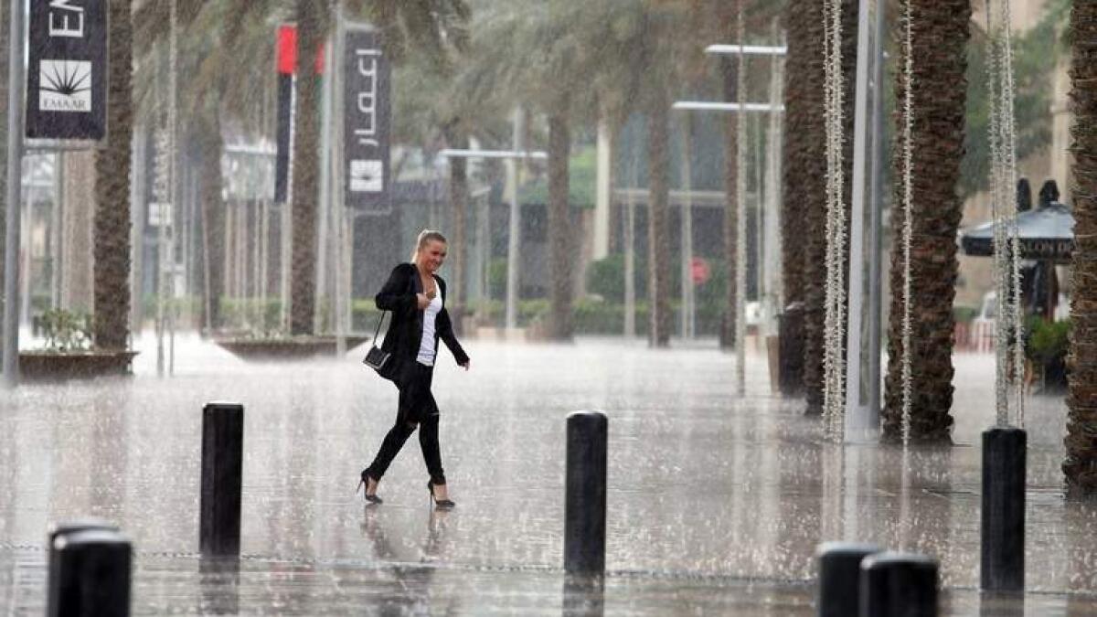 A lady walks in Downtown Dubai during the rain.
