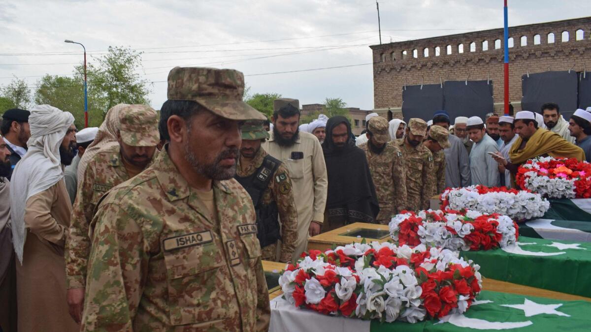 Relatives and security officials gather around the coffins of policemen who were killed by a roadside bomb in Lakki Marwat district of Khyber Pakhtunkhwa province on Thursday. — AFP