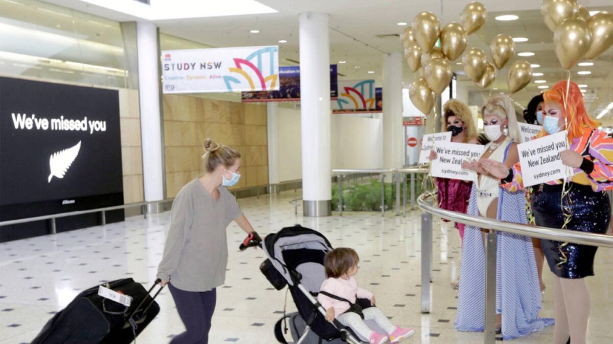Passengers from New Zealand are welcomed at Sydney Airport. — AP