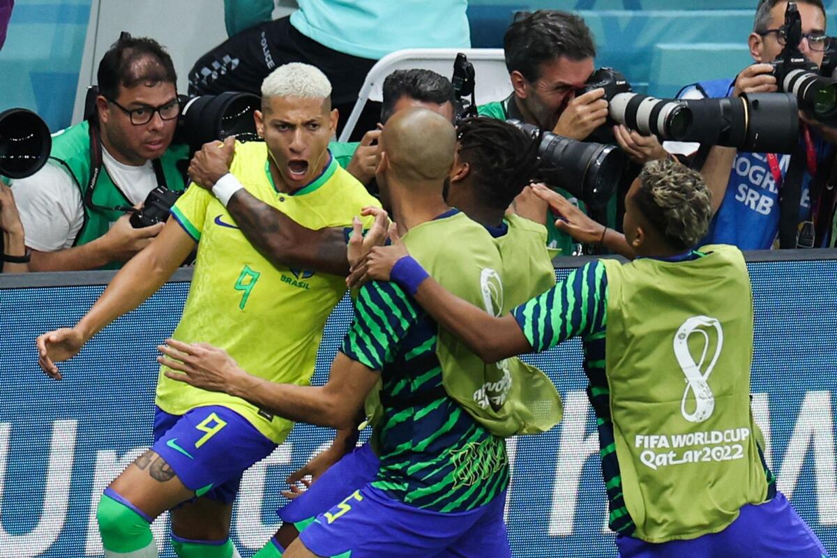 Brazil forward Richarlison (9) celebrates with teammates after scoring his team's first goal. (AFP)