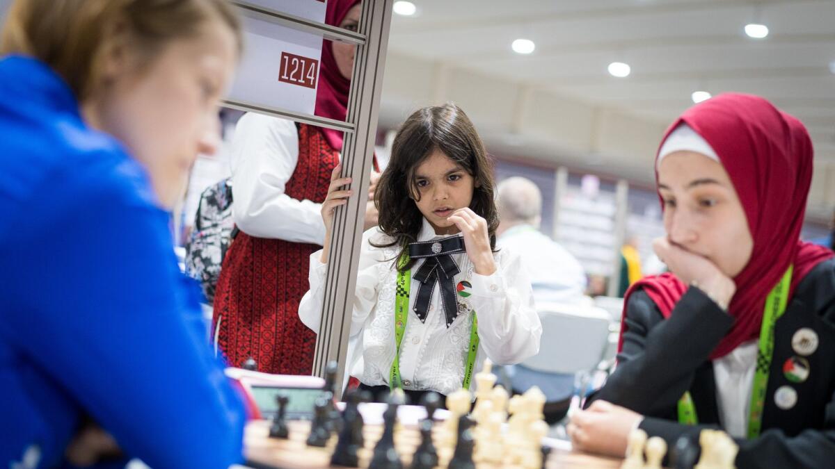 Randa Seder (centre) from Palestine watches her teammate in action. — FIDE