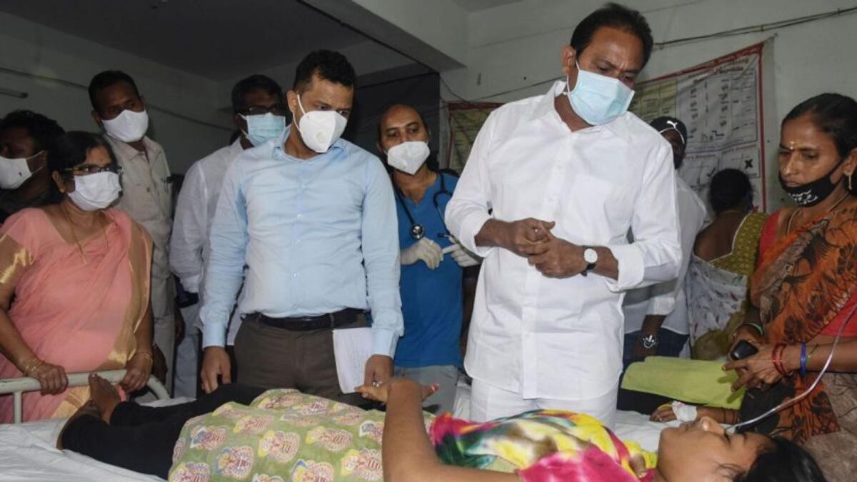 Andrha Pradesh health minister Alla Nani (second right) visits patients receiving medical care for the mystery illness.