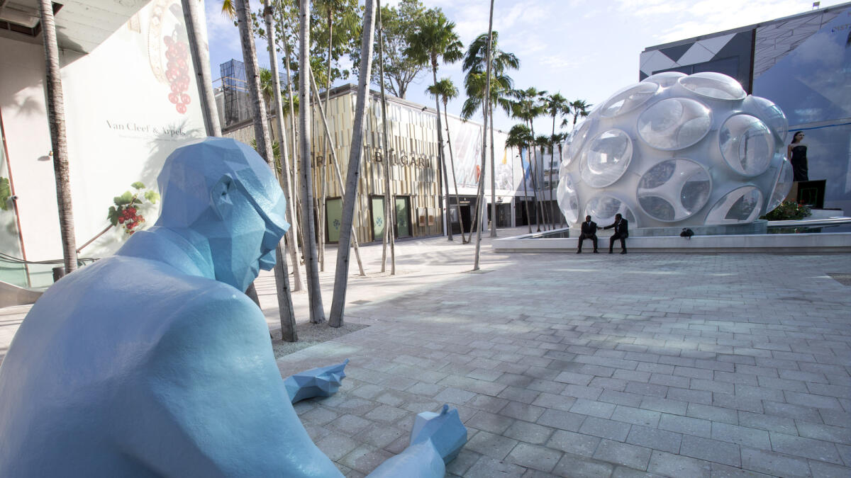 In this Oct. 30, 2015 photo, a sculpture of the late architect Le Corbusier by the French artist Xavier Veilhan, appears across from the Fly?s Eye Dome, designed by Neo-Futuristic architect Richard Buckminster Fuller,  in the Miami Design District in Miami.