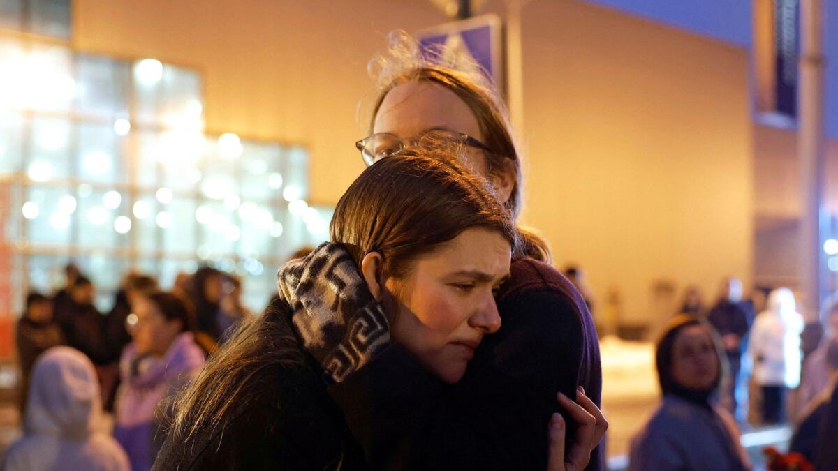 A woman reacts in front of a makeshift memorial to the victims of a shooting attack set up outside the Crocus City Hall concert venue in Moscow. — Reuters