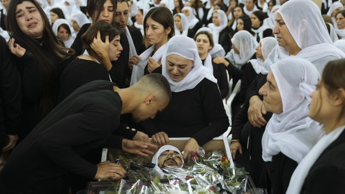 Members of the Israeli Druze minority mourn around the body of Tiran Fero, 17, during his funeral in Daliyat al-Carmel, Israel, on Nov. 24, 2022.