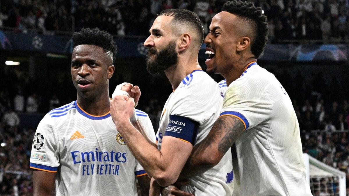 Real Madrid forward Karim Benzema (centre) celebrates with Vinicius Junior (left) and Eder Militao after scoring his team's third goal against Manchester City. (AFP)