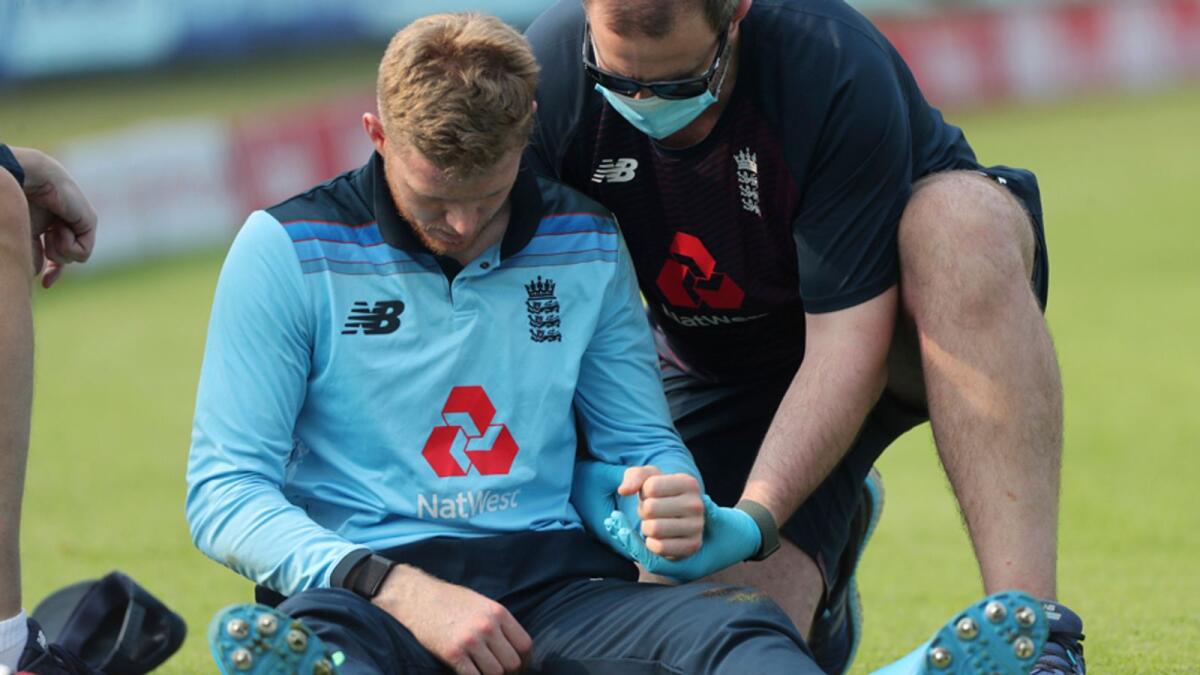 England's Sam Billings is attended by a member of team support staff after injuring himself while fielding at the boundary during the first One Day International cricket match against India in Pune, India. — AP