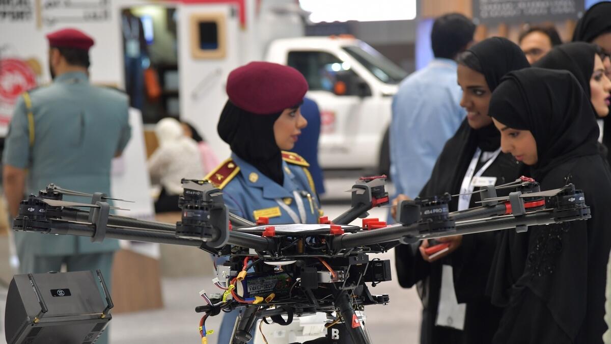 A policewoman stands next to a drone at the Gitex 2017 technology exhibition at the Dubai World Trade Center.- AFP