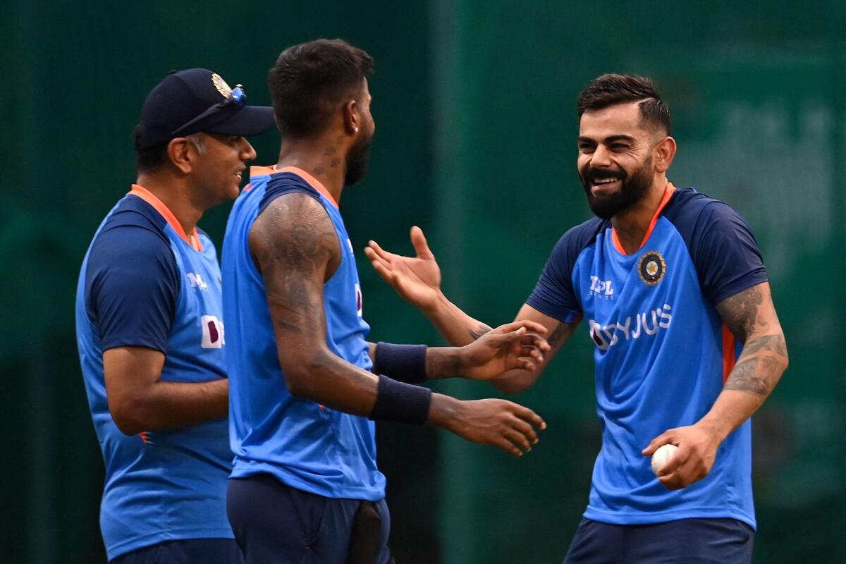 India's Virat Kohli (right) speaks with his team coach Rahul Dravid (left) and teammate Hardik Pandya during a practice session in Mohali on Monday. (AFP)
