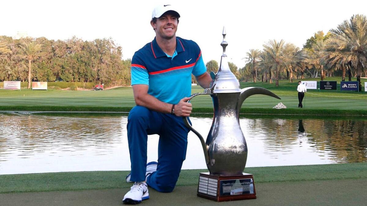 Rory McIlroy poses with the famous Dallah Trophy close to  the 18th green at the Emirates Golf Club. - Supplied photo