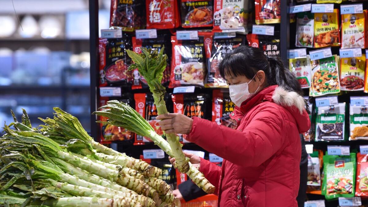 A woman shops for vegetables at a supermarket in Nanjing, in China's eastern Jiangsu province. — AFP