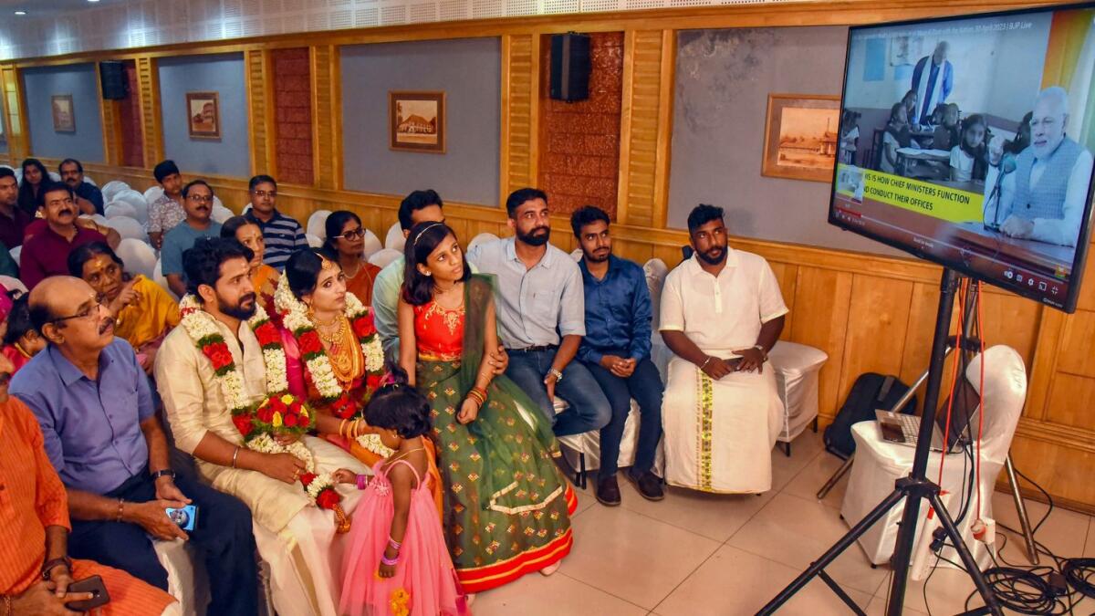 Bride and groom listen to the 100th episode of Prime Minister Narendra Modi’s ‘Mann Ki Baat’ radio programme during their marriage ceremony in Kochi, Kerala. — PTI