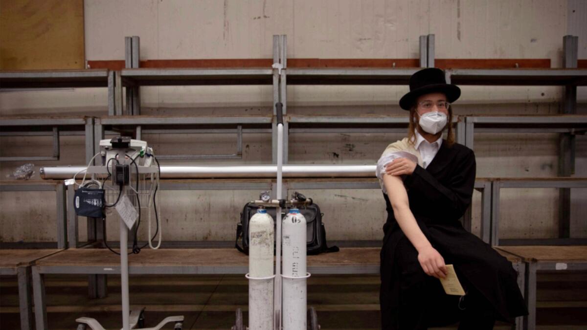 A Jewish man rests after receiving his second dose of the Pfizer Covid-19 vaccine at a  vaccination centre set up at a synagogue in Bnei Brak, Israel. — AP