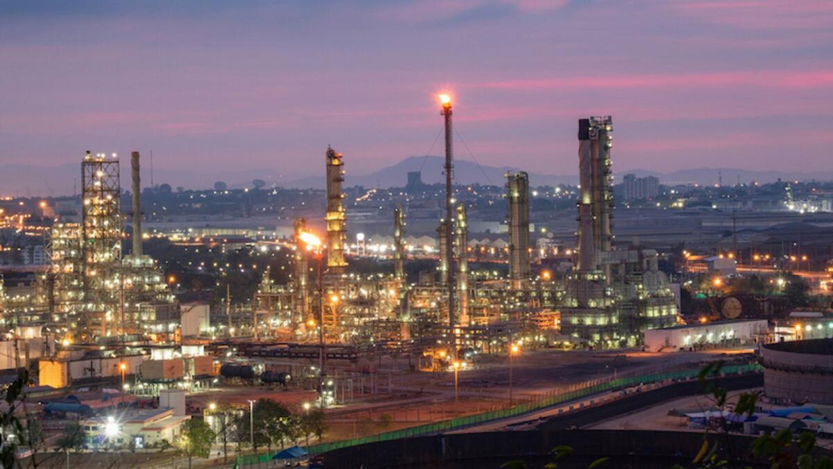 An oil refinery is lit up by lights in Saudi Arabia. The rating agency said fiscal balances would remain in surplus in UAE and Qatar in an average oil price scenario of $75/barrel but turn into moderate deficits in Kuwait, Oman, and Saudi Arabia.