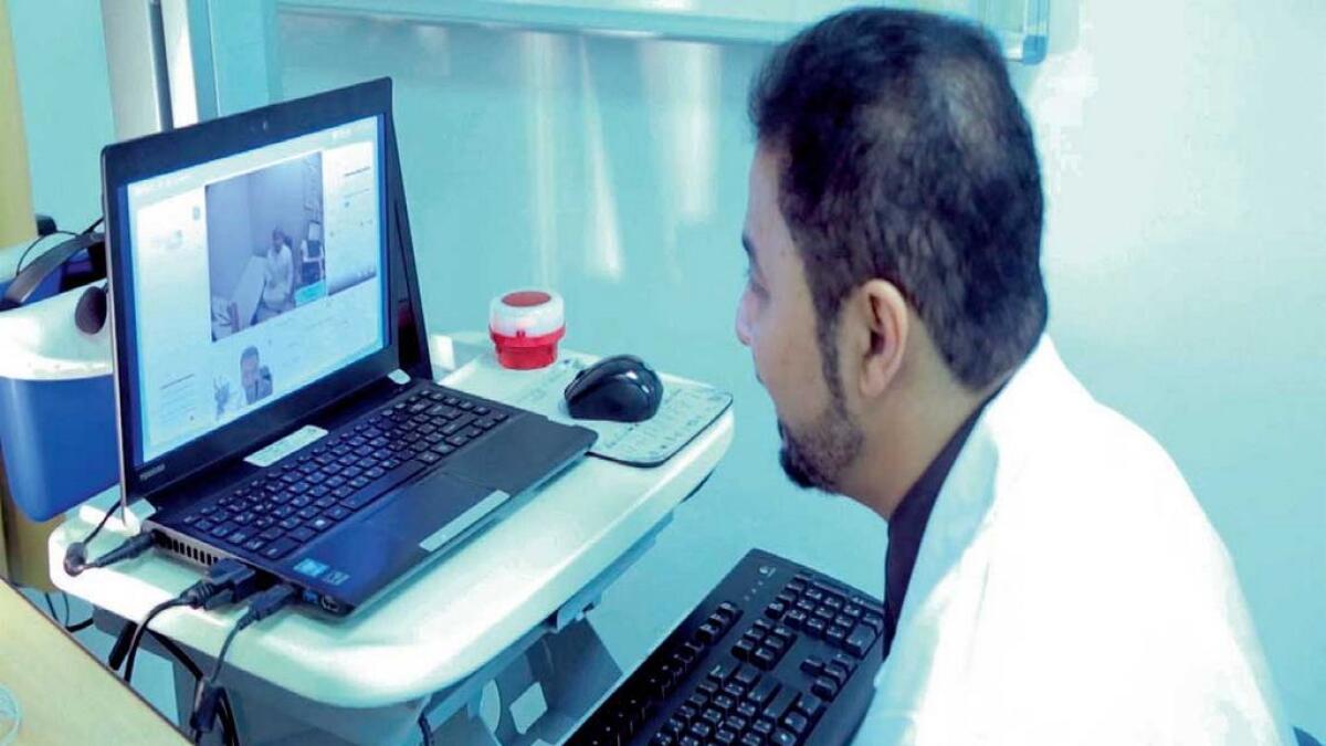 A doctor from Rashid Hospital communicates with a team at Hatta Hospital to provide consultation through RoboDoc.