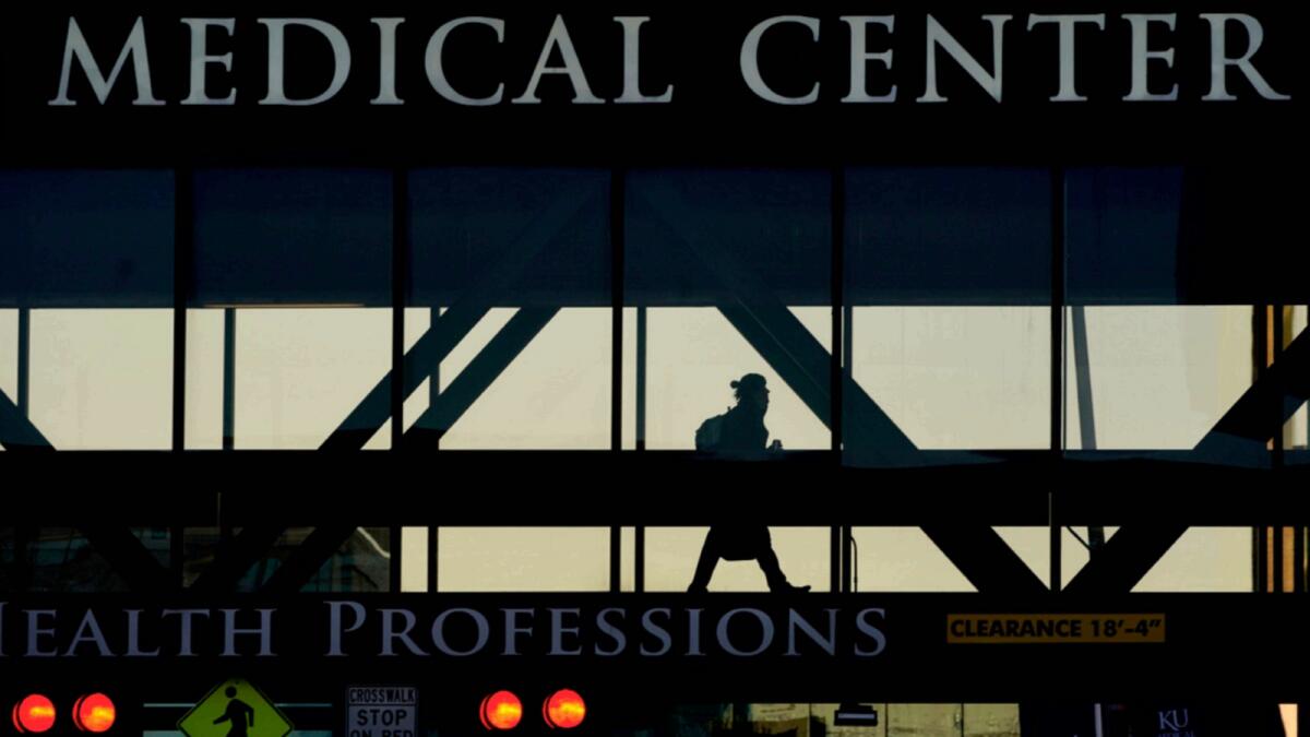 A person walks between buildings at the University of Kansas Hospital. — AP