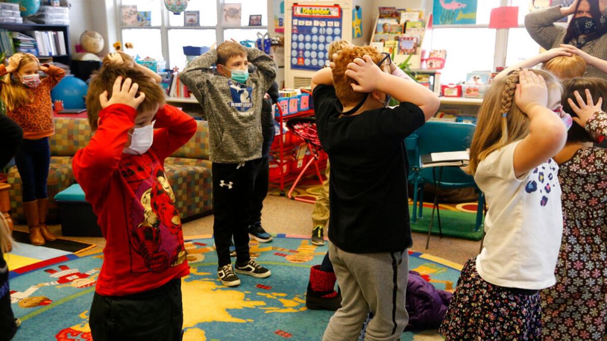 Pupils hold their heads as they talk about thoughts and how they compare with feelings and resulting actions, at Paw Paw Elementary School in  Michigan. – AP