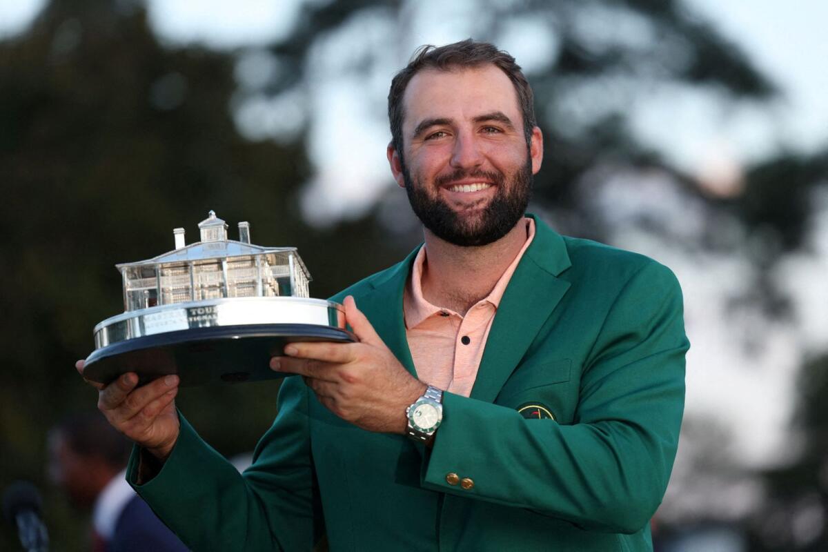 Scottie Scheffler of the US celebrates with his green jacket and the trophy after winning the Masters. — Reuters