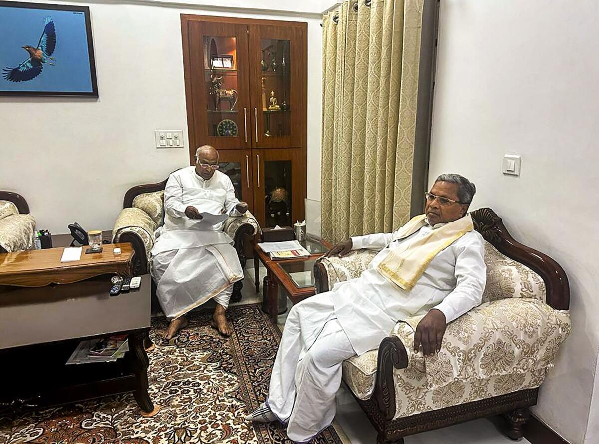 Congress President Mallikarjun Kharge interacts with senior party leader Siddaramaiah during a meeting at his residence  on  Tuesday. Photo: PTI