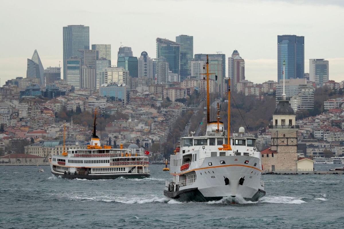 Ferries, with the city's skyscrapers in the background, sail in the Bosphorus in Istanbul.
