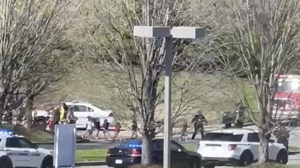 Law enforcement officers lead children away from the scene of a shooting at The Covenant School, a private Christian school in Nashville. — AP
