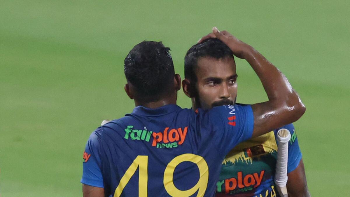 Sri Lanka's Chamika Karunaratne (left) and Wanindu Hasaranga celebrate after winning the Asia Cup match against Afghanistan at the Sharjah Cricket Stadium. (AFP)