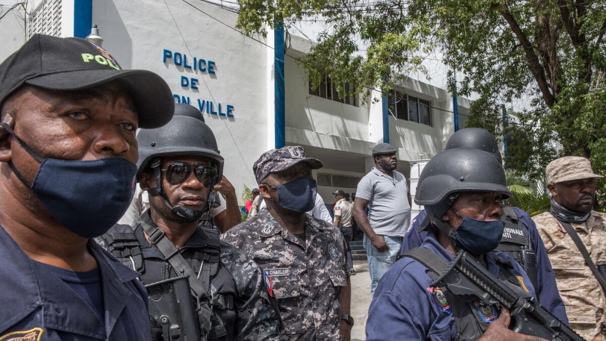 Leon Charles, head of the Police Ntionale of Haiti (centre), looks on as the crowd surrounds the Petionville Police station in Port au Prince. Photo: AFP