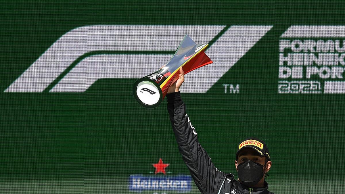 Mercedes' British driver Lewis Hamilton celebrates on the podium after winning the Portuguese Formula One Grand Prix. — AFP