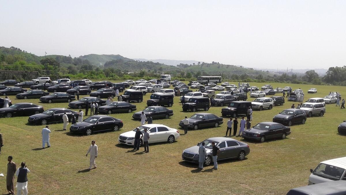 People visit an auction of government owned used cars at the premises of Prime Minister House in Islamabad, Pakistan.- Reuters