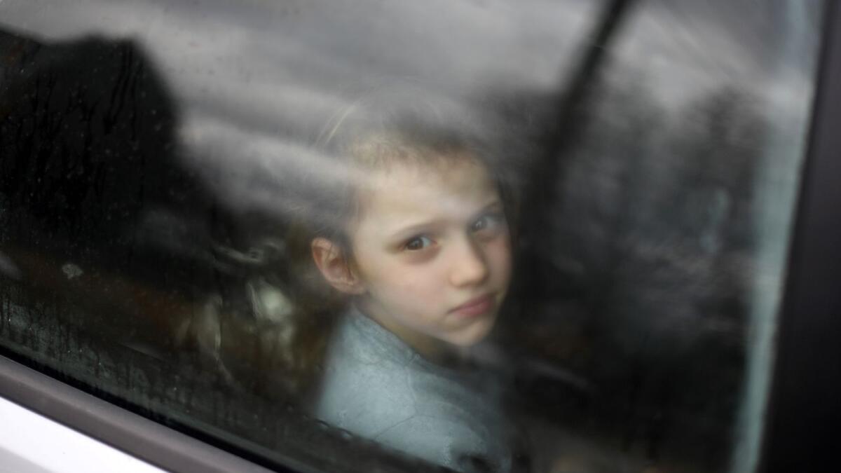 An Ukrainian child looks through the window of a car stuck in traffic, as her family drives towards the Medyka-Shehyni border crossing between Ukraine and Poland while fleeing the conflict in their country, near the Ukrainian village of Tvirzha, some 20km from the border, on February 28, 2022. (Photo: AFP)