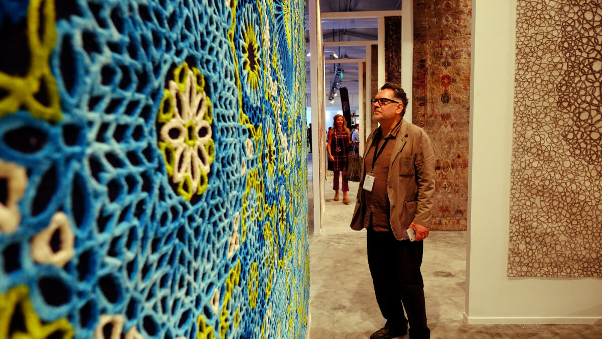 CAPTIVATED ... An art enthusiast enjoys the intricate design of an exhibited artwork at the Samovar carpets and antique pavilion at Downtown Design at Dubai Design District.