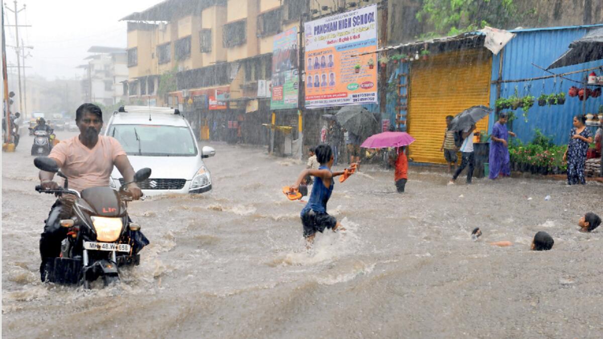 A man rides his bike on water logged road as it rains in Mumbai on Friday. (ANI Photo)