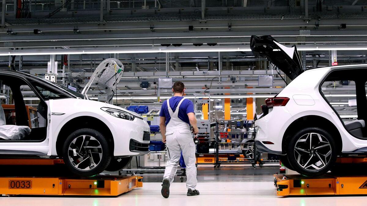 An employee of German car maker Volkswagen (VW) works on an assembly line to produce the Volkswagen ID.3 electric car model at the Volkswagen car factory in Zwickau, eastern Germany. — AFP file