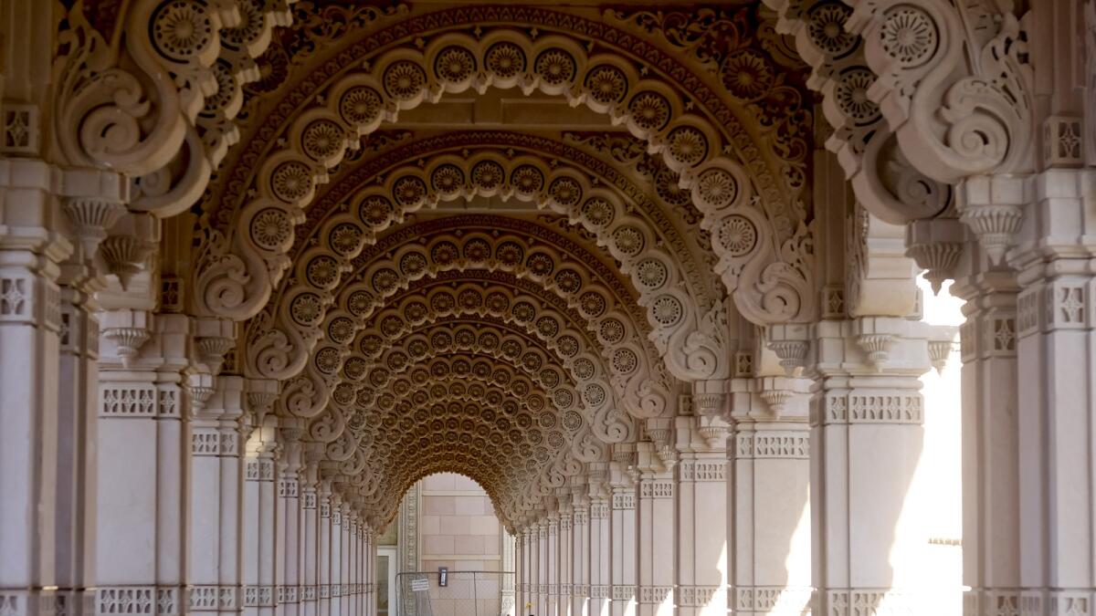 A man at the BAPS Swaminarayan Akshardham checks his phone inside the garland-like path, or parikrama, which serves as an ornate covered walkway to the largest Hindu temple outside India in the modern era. — AP