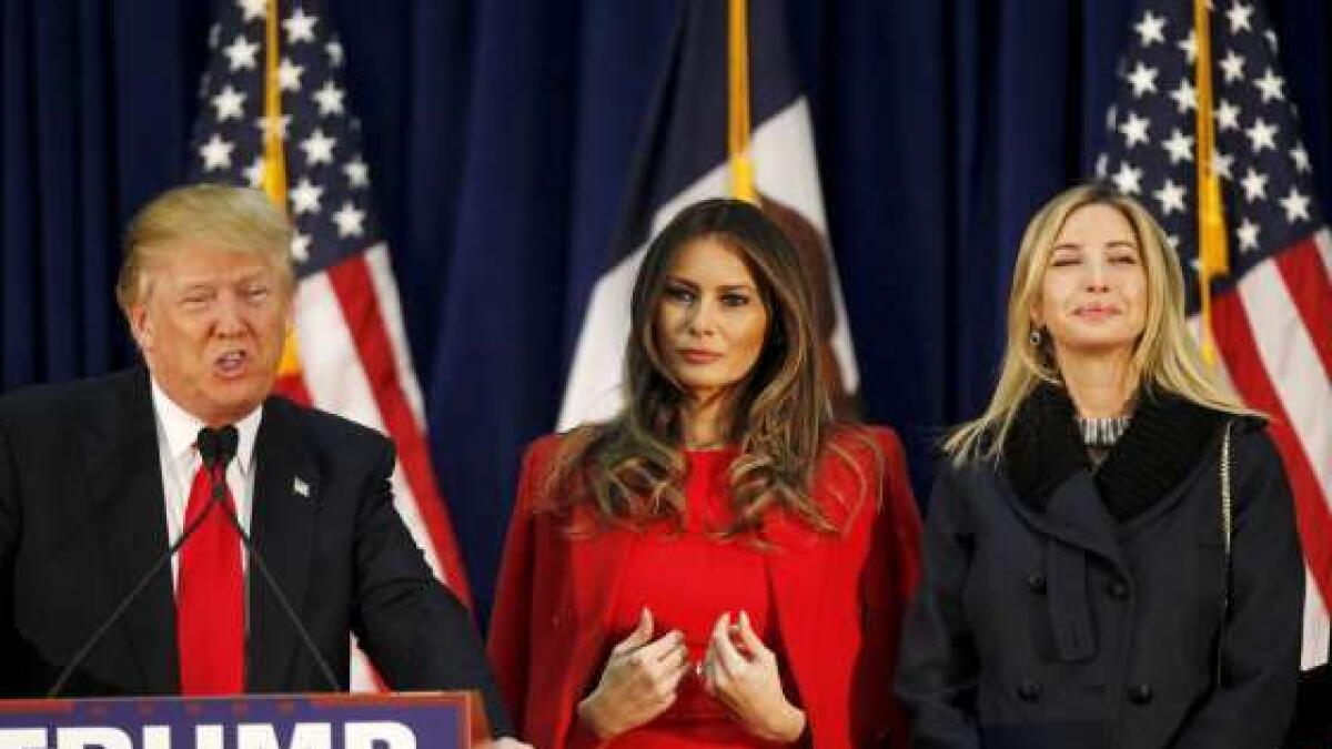 Donald Trump speaks as his wife Melania and daughter Ivanka listen at a campaign rally on caucus day in Waterloo, Iowa, February 1, 2016.