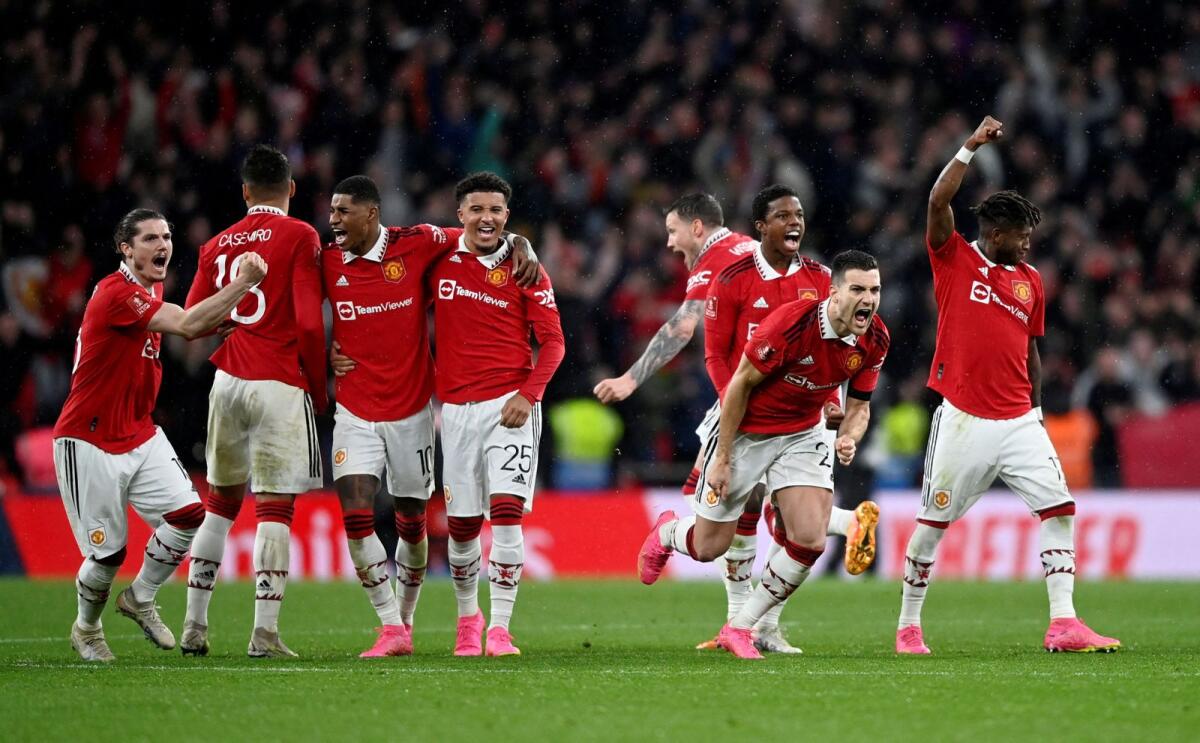 Manchester United players celebrate after winning the penalty shootout. — Reuters