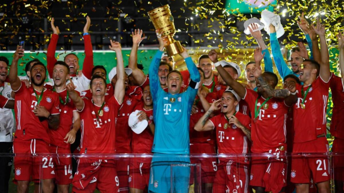 Bayern Munich's German goalkeeper Manuel Neuer raises the German Cup (DFB Pokal) trophy as he and his teammates celebrate winning the final football match Bayer 04 Leverkusen v FC Bayern Munich at the Olympic Stadium in Berlin on July 4, 2020. Photo AFP