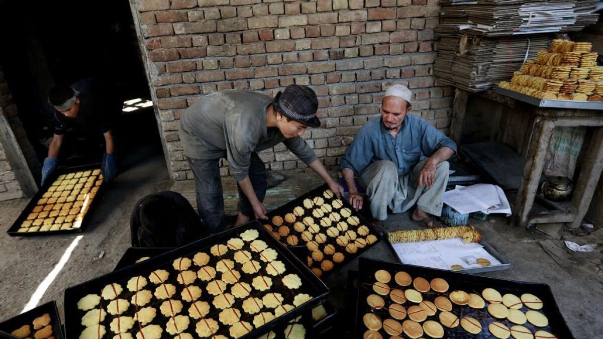 Afghan vendors prepare sweets at a traditional bakery for the upcoming Eid al-Fitr