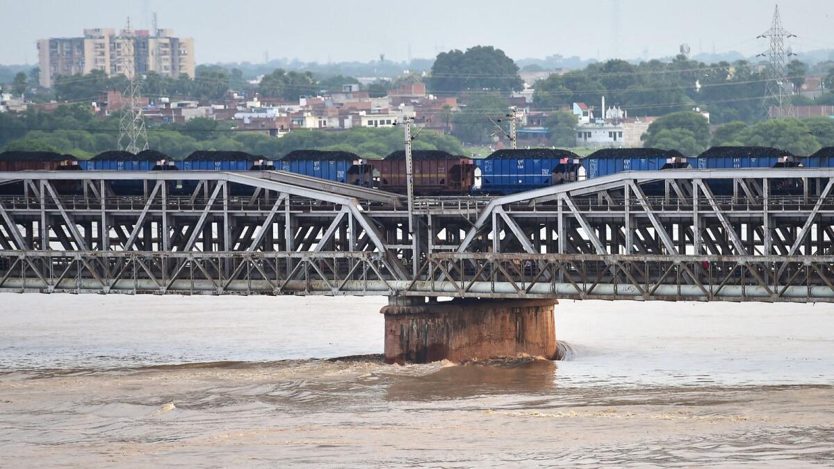 A freight train crosses the old Yamuna Bridge over the Yamuna River in Allahabad, India. — AFP
