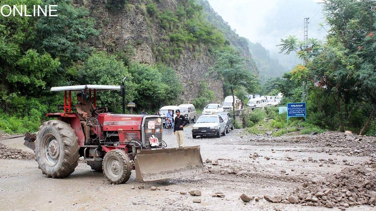 A tractor is being used to remove landslide debris from the Murree road, after heavy rain lashed the area.