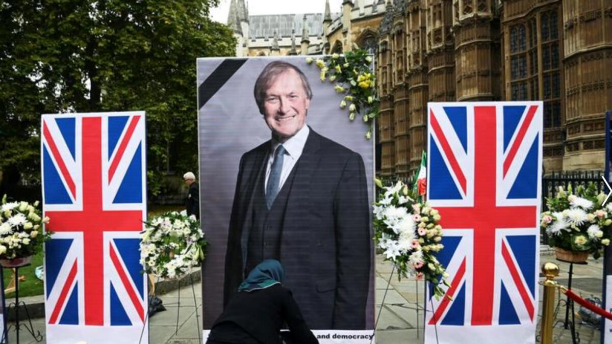 Residents build a temporary memorial of David Amess of the Houses of Parliament in London. – Reuters