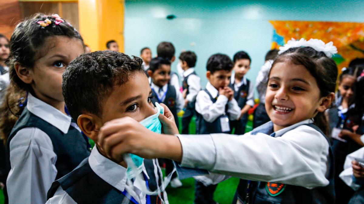 A girl applies a mask onto the face of a boy during an awareness session about Covid-19 disease held by a local kindergarten in Gaza City, as education facilities in the Palestinian enclave re-opened for the new 2020-2021 academic year following an easing of pandemic restrictions. Photo: AFP