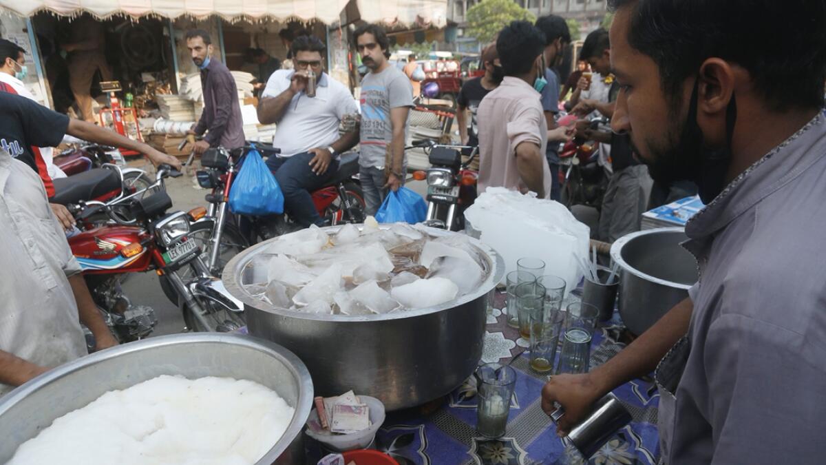 A Pakistani vendor sells cold drinks to customers at a roadside as temperature reached 41 degrees Celsius (106 Fahrenheit) in Lahore, Pakistan. Photo: AP