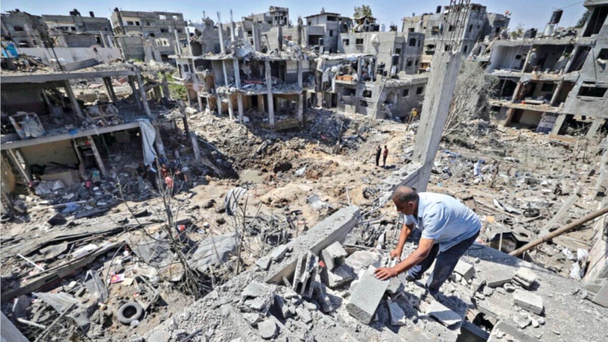 Palestinians assess the damage caused by Israeli air strikes, in Beit Hanun in the northern Gaza Strip. — AFP file