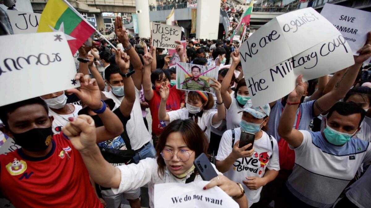 Myanmar citizens in Bangkok hold placards as they take part in a protest against the military coup in Myanmar. — Reuters