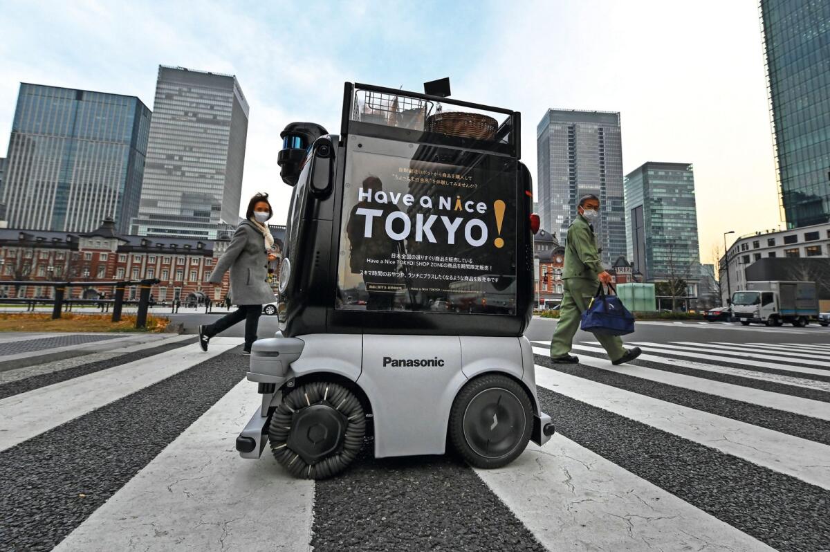 This picture taken on January 13, 2023 shows a delivery robot Hakobo selling hot drinks and snacks in Tokyo's shopping and business area of Marunouchi near Tokyo Station. 'Excuse me, coming through,' a four-wheeled robot chirps as it dodges pedestrians on a street outside Tokyo, part of an experiment businesses hope will tackle labour shortages and rural isolation.
